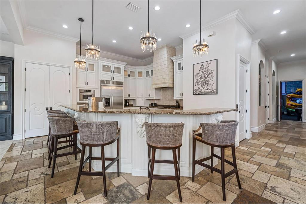 304 Muirfield Loop Reunion, FL 34747 - Photo 18 of 85 a kitchen with stainless steel appliances kitchen island granite countertop a stove a sink and a refrigerator