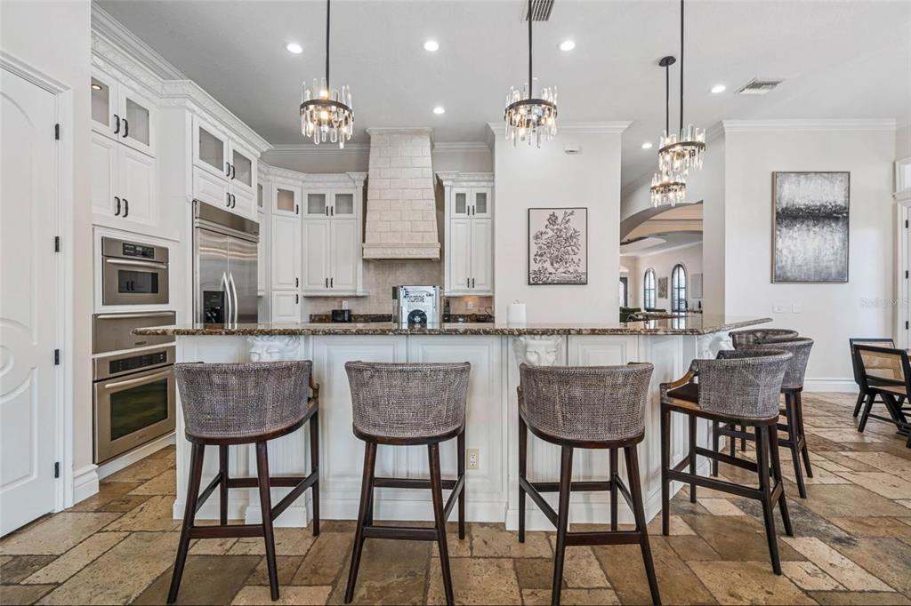 304 Muirfield Loop Reunion, FL 34747 - Photo 19 of 85 a kitchen with granite countertop a table chairs stove and cabinets