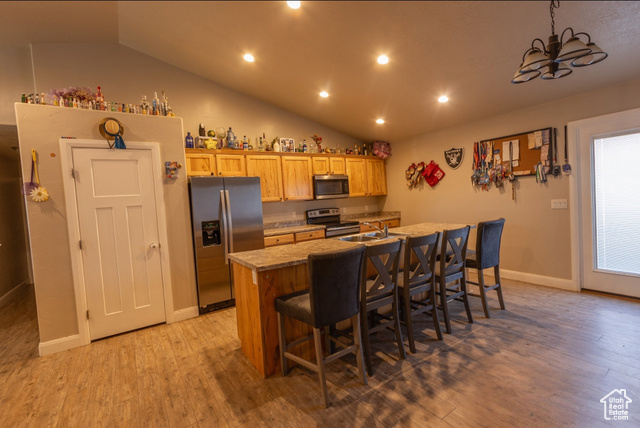 660 East 400 North Spring City, UT 84662 - Photo 4 of 16 Kitchen featuring a center island with sink, light wood-style floors, stainless steel appliances, and a kitchen bar