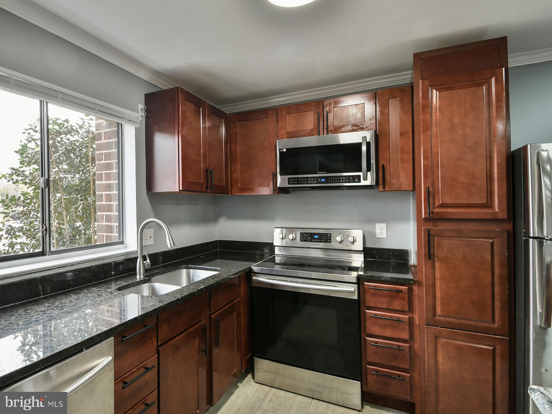 15712 Dorset Road, Unit 104 Laurel, MD 20707 - Photo 13 of 49 a kitchen with a refrigerator stove and microwave
