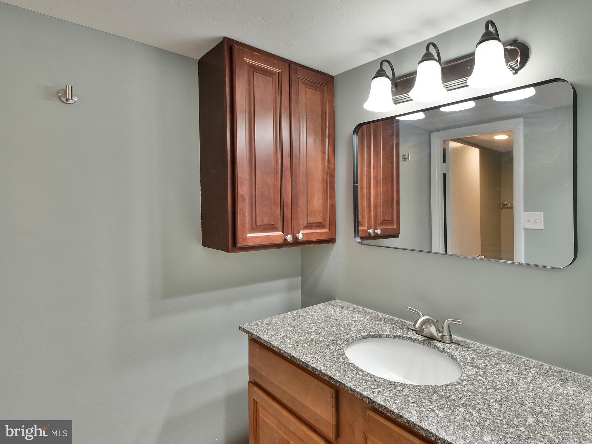 15712 Dorset Road, Unit 104 Laurel, MD 20707 - Photo 28 of 49 a bathroom with a granite countertop sink and a mirror