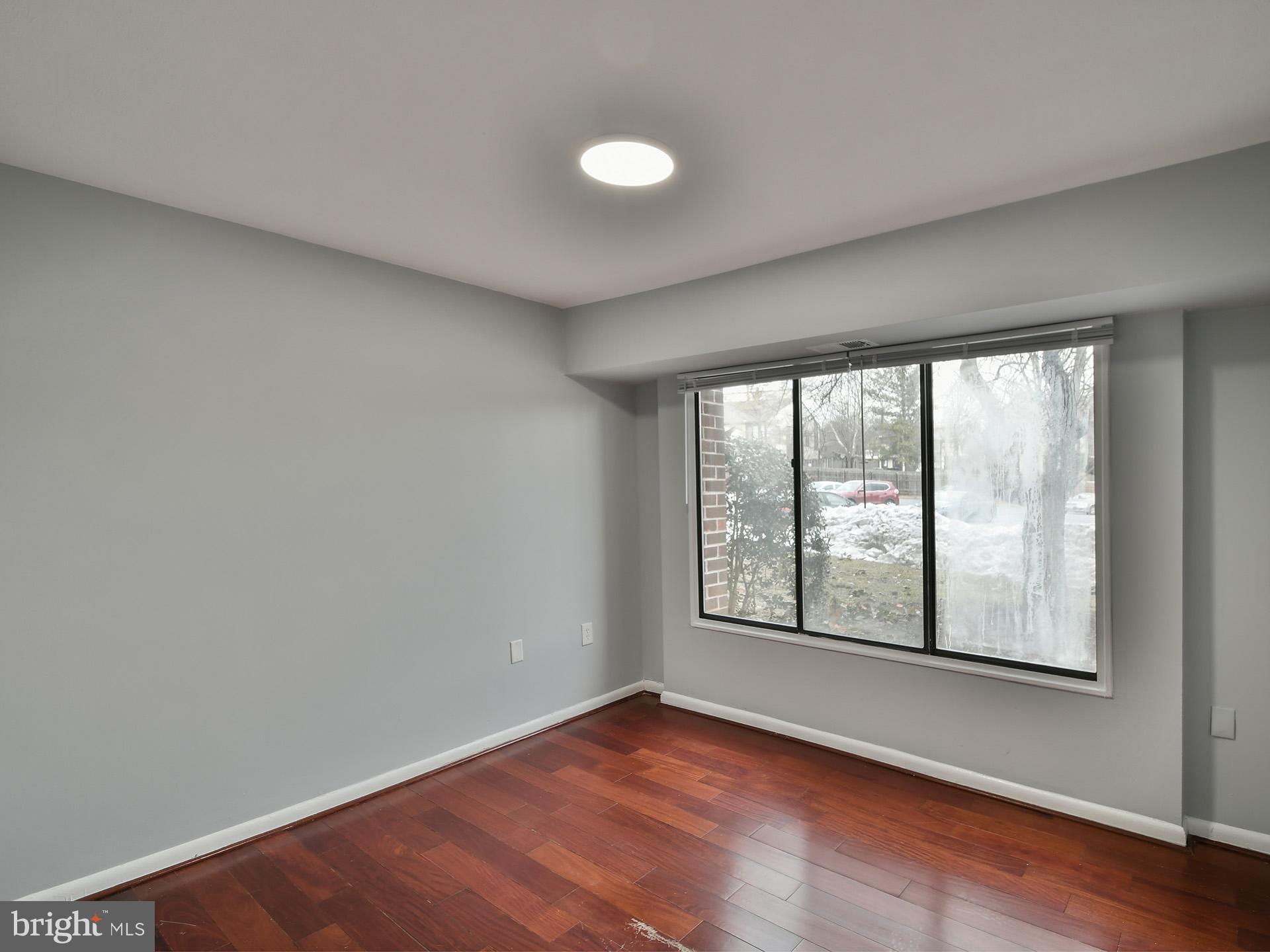 15712 Dorset Road, Unit 104 Laurel, MD 20707 - Photo 30 of 49 an empty room with wooden floor and windows