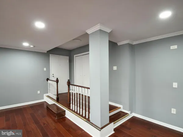 a view of a hallway with wooden floor and seating