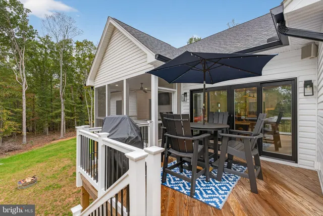 a kitchen with white cabinets a window and wooden floor