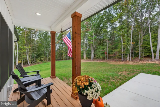 a kitchen with stainless steel appliances granite countertop a stove a refrigerator a sink dishwasher and a dining table with wooden floor