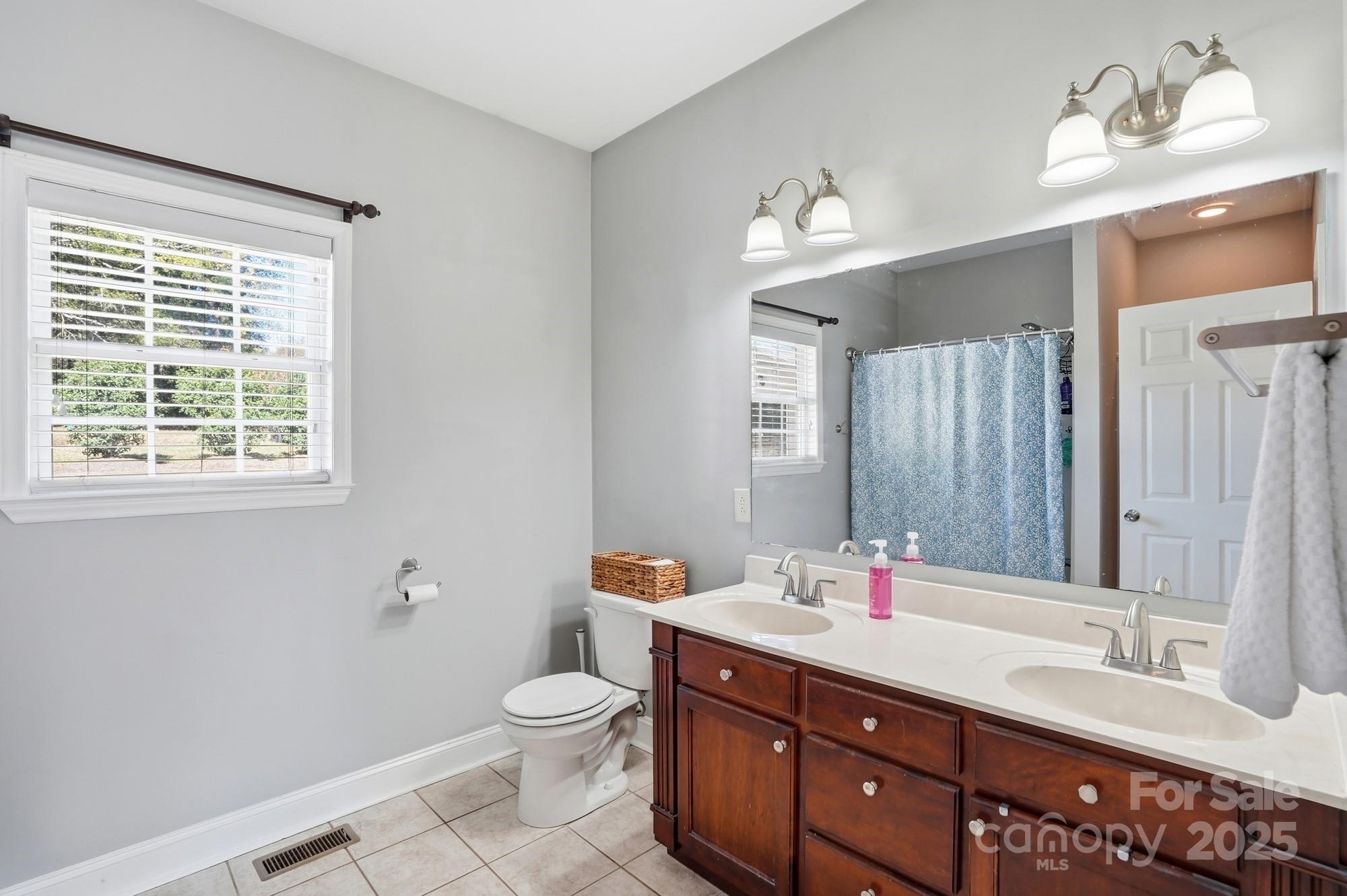 213 Carrie Road Oakboro, NC 28129 - Photo 16 of 40 a bathroom with a double vanity sink toilet and a mirror