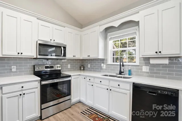 a kitchen with stainless steel appliances granite countertop a stove a sink and a microwave