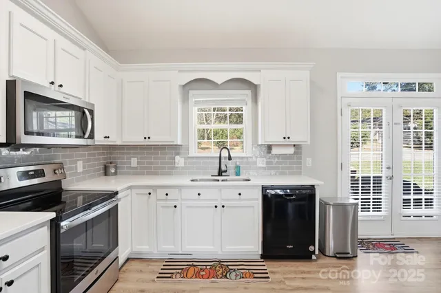 a dining room with stainless steel appliances a dining table and chairs