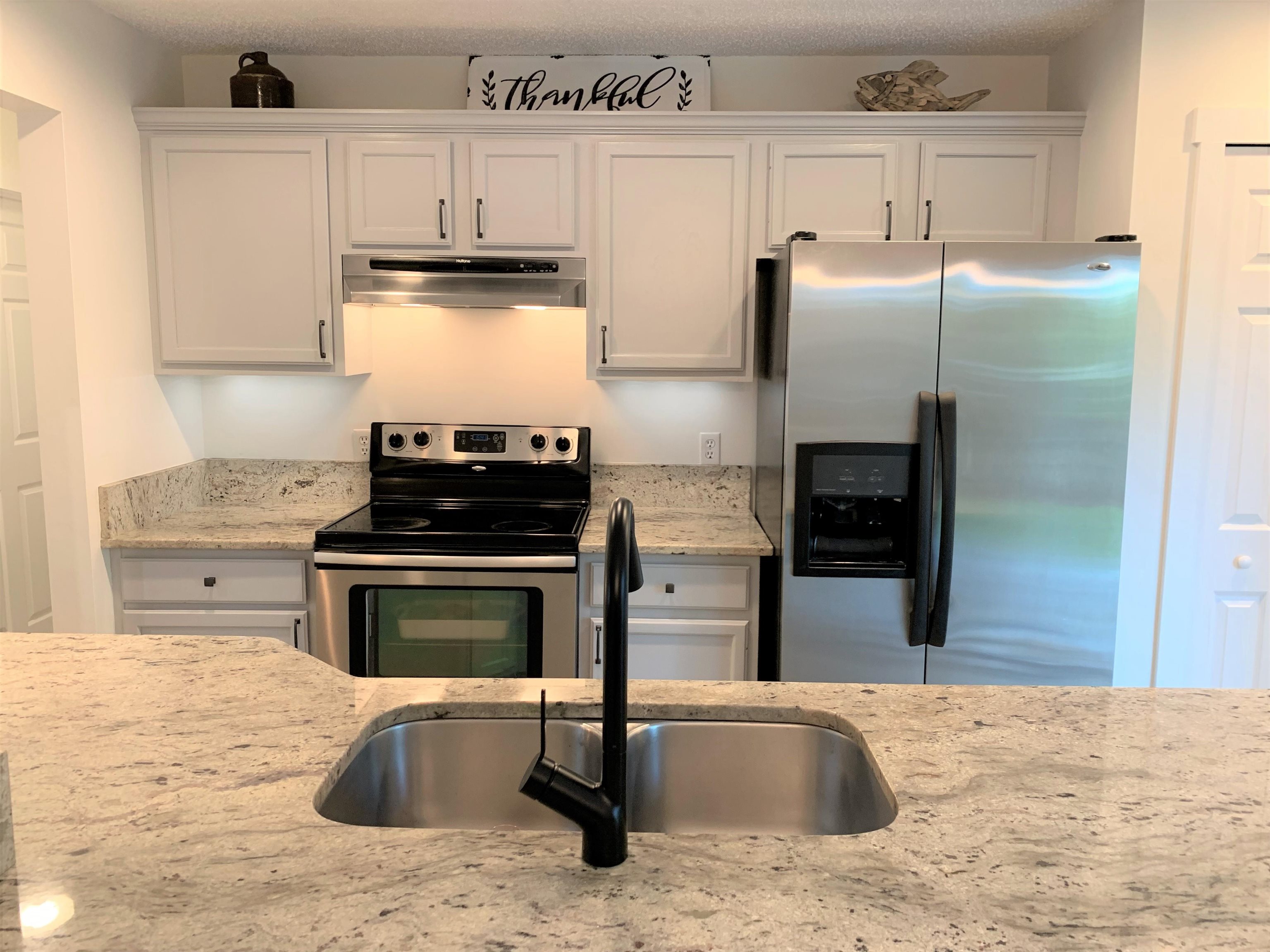 215 Yale Road St. Augustine, FL 32086 - Photo 13 of 35 a kitchen with granite countertop a refrigerator and a stove