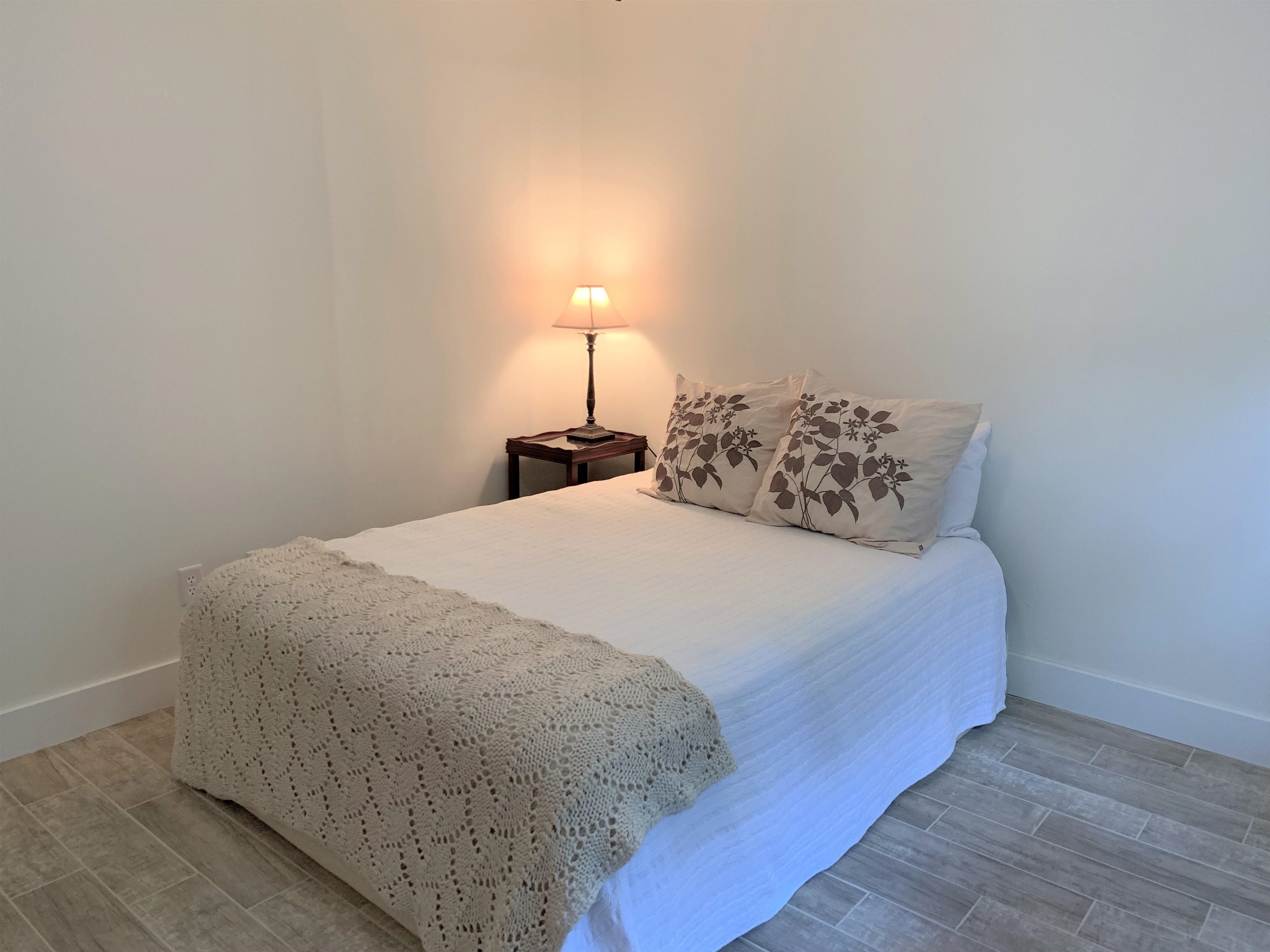 215 Yale Road St. Augustine, FL 32086 - Photo 26 of 35 a bed sitting in a bedroom next to a lamp