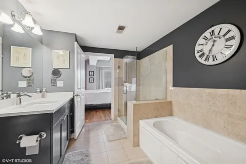 a bathroom with a tub a double vanity sink and a mirror