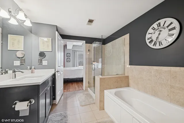 a bathroom with a tub a double vanity sink and a mirror