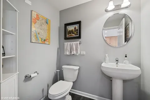 a bathroom with a toilet a sink and mirror