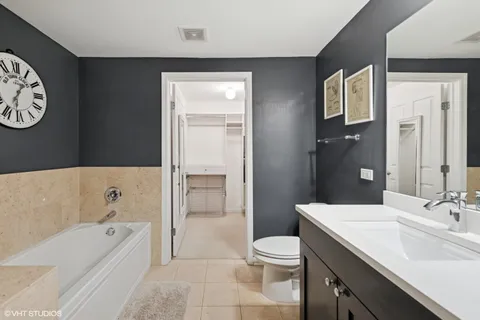 a bathroom with a bathtub shower sink mirror vanity and a toilet