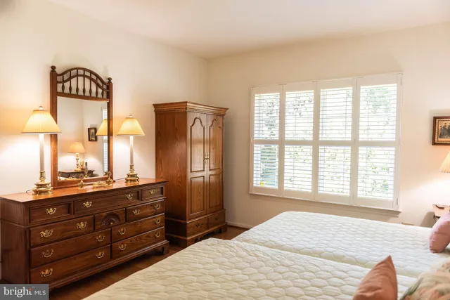 a bedroom with a bed and large windows