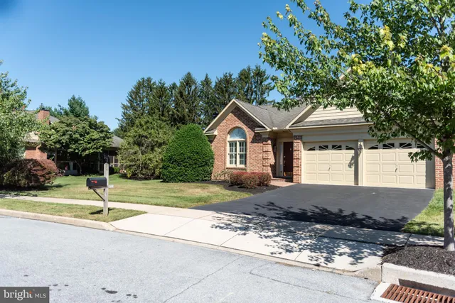 a view of a house with a yard and large tree