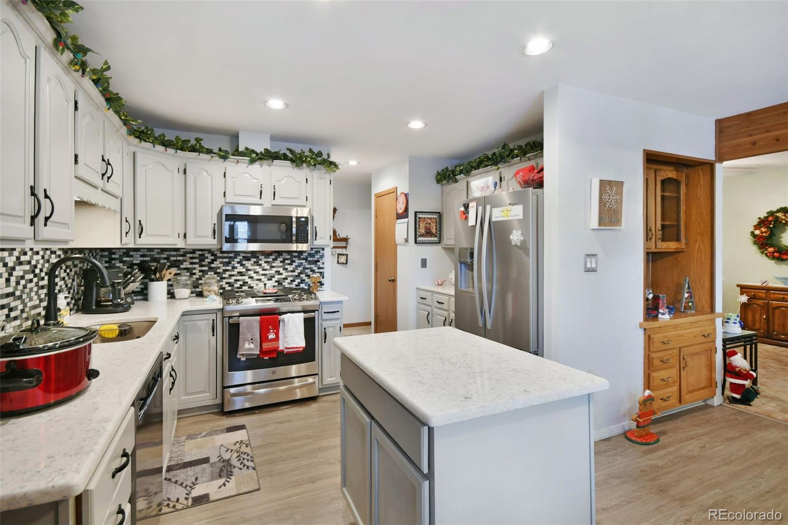 1360 Yank Street Golden, CO 80401 - Photo 12 of 26 a kitchen with stainless steel appliances kitchen island granite countertop a refrigerator a stove top oven and a sink