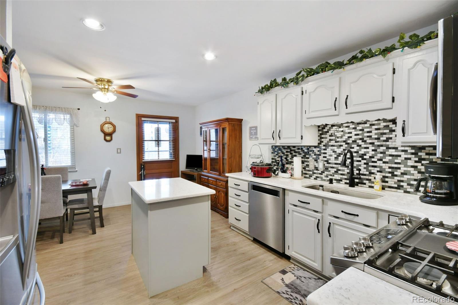 1360 Yank Street Golden, CO 80401 - Photo 13 of 26 a kitchen with stainless steel appliances a sink a stove a refrigerator cabinets and living room view