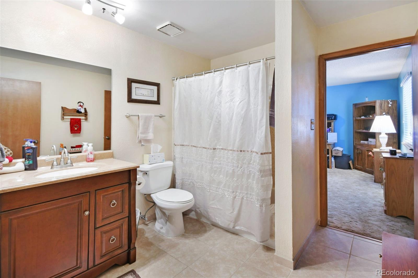1360 Yank Street Golden, CO 80401 - Photo 22 of 26 a spacious bathroom with a sink a toilet and a mirror