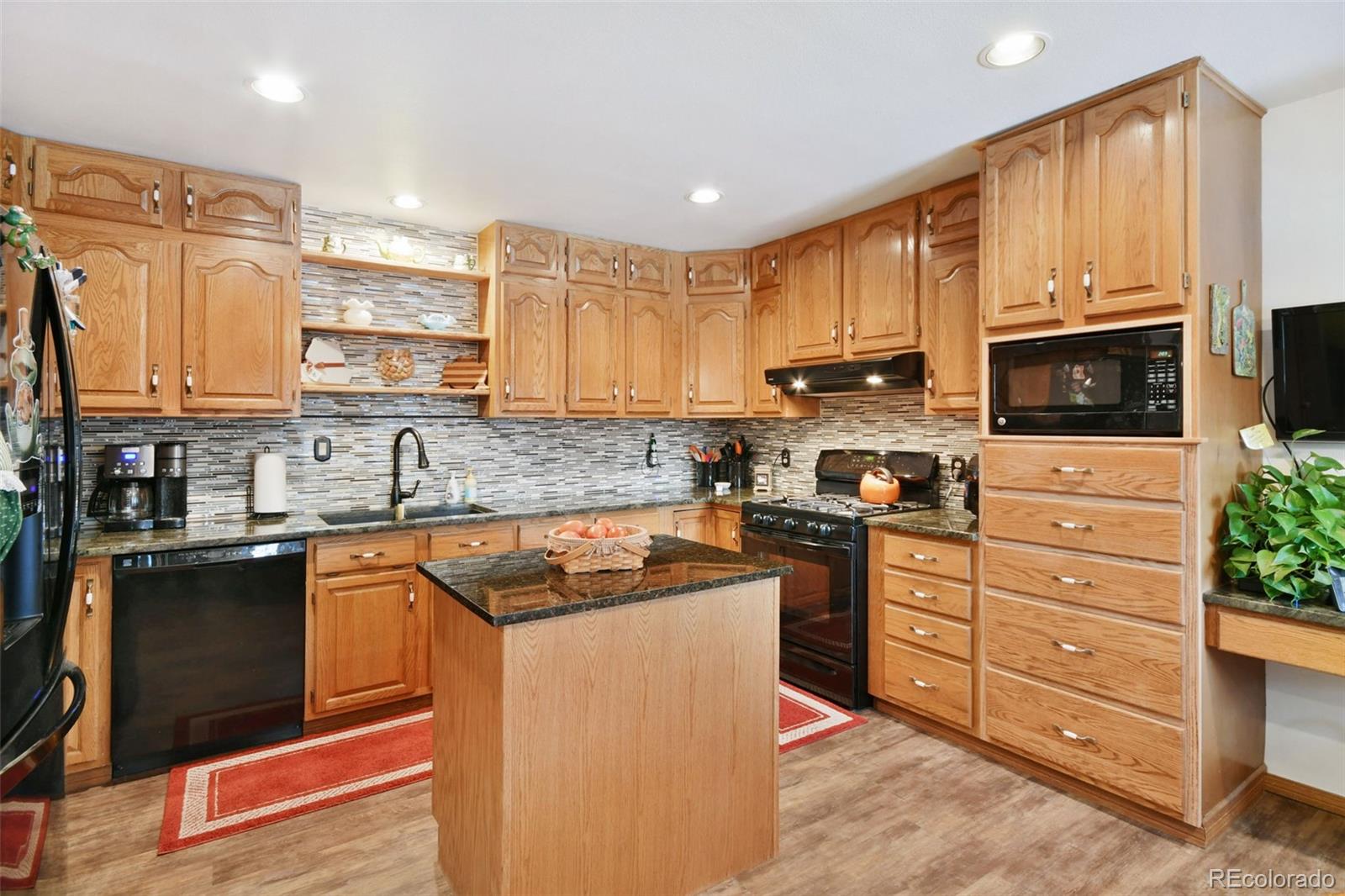 1360 Yank Street Golden, CO 80401 - Photo 5 of 26 a kitchen with stainless steel appliances granite countertop a stove top oven a sink dishwasher a dining table and chairs with wooden floor