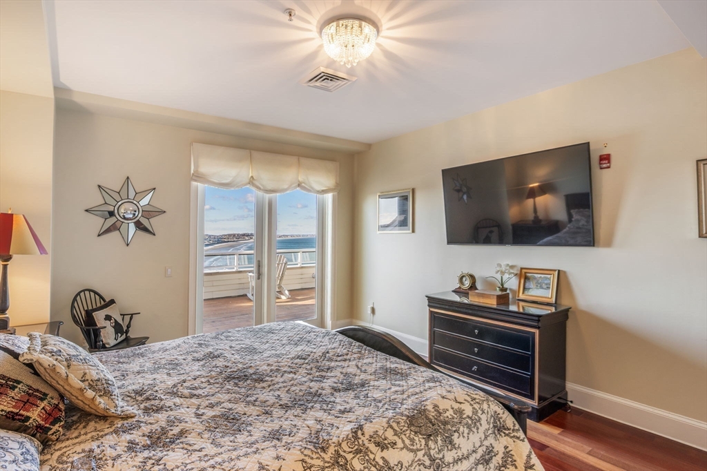 1 Longbeach Avenue, Unit 202 Hull, MA 02045 - Photo 20 of 40 a bedroom with a bed and a flat screen tv