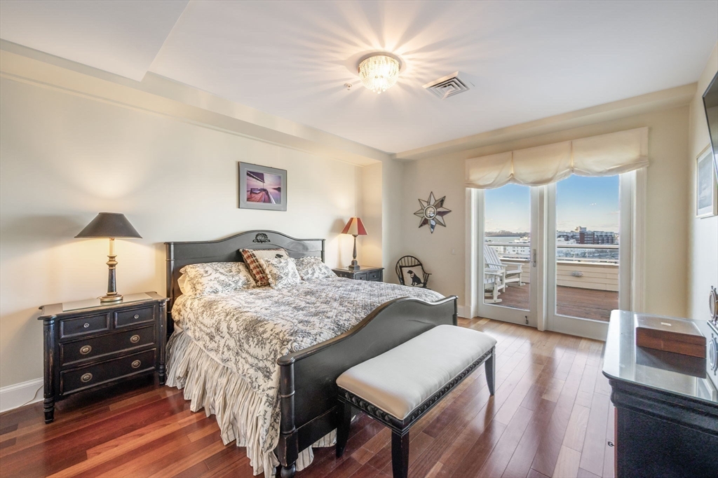 1 Longbeach Avenue, Unit 202 Hull, MA 02045 - Photo 21 of 40 a bedroom with a bed and a flat tv screen on dresser