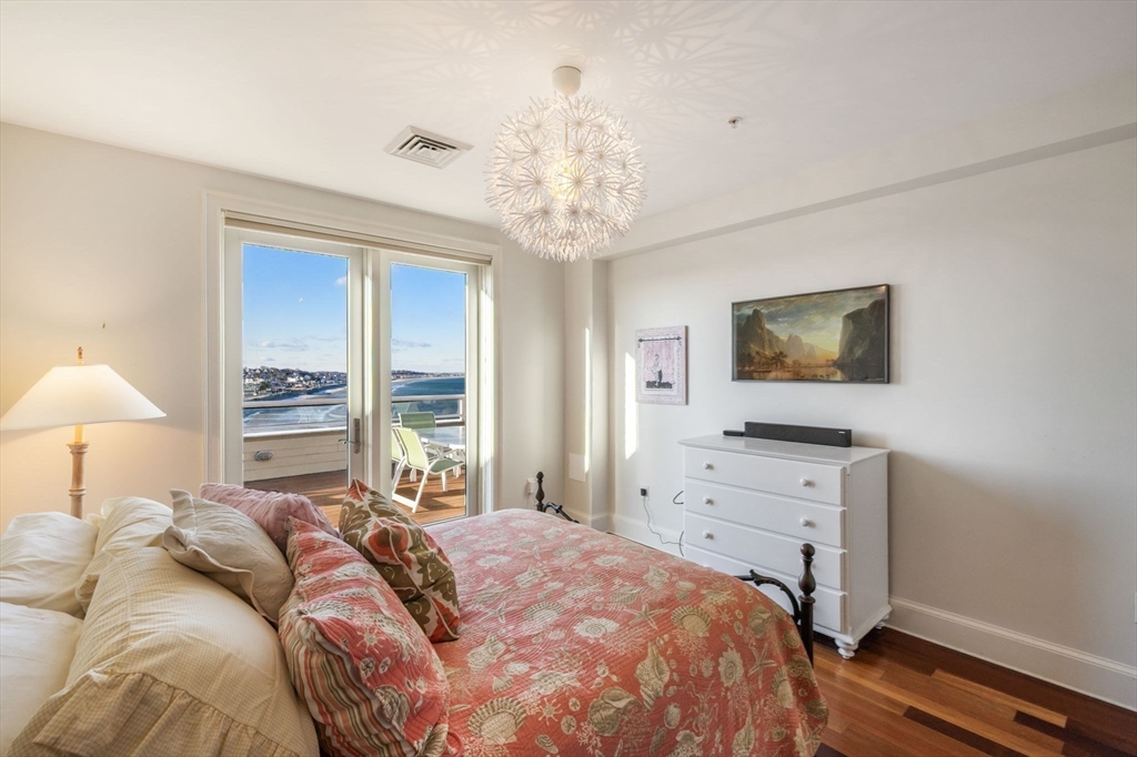 1 Longbeach Avenue, Unit 202 Hull, MA 02045 - Photo 26 of 40 a bedroom with a bed and a flat tv screen on dresser