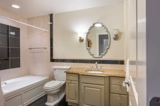 a bathroom with a toilet a sink and a mirror