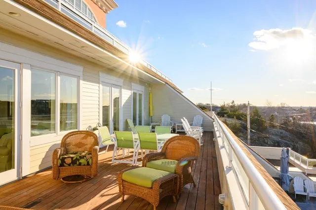 a balcony with chairs and with potted plants