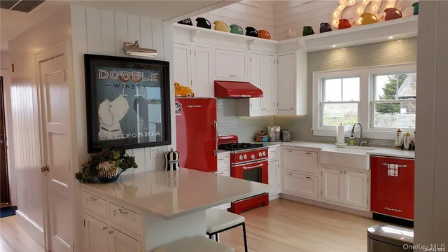 a kitchen with stainless steel appliances a sink cabinets and wooden floor