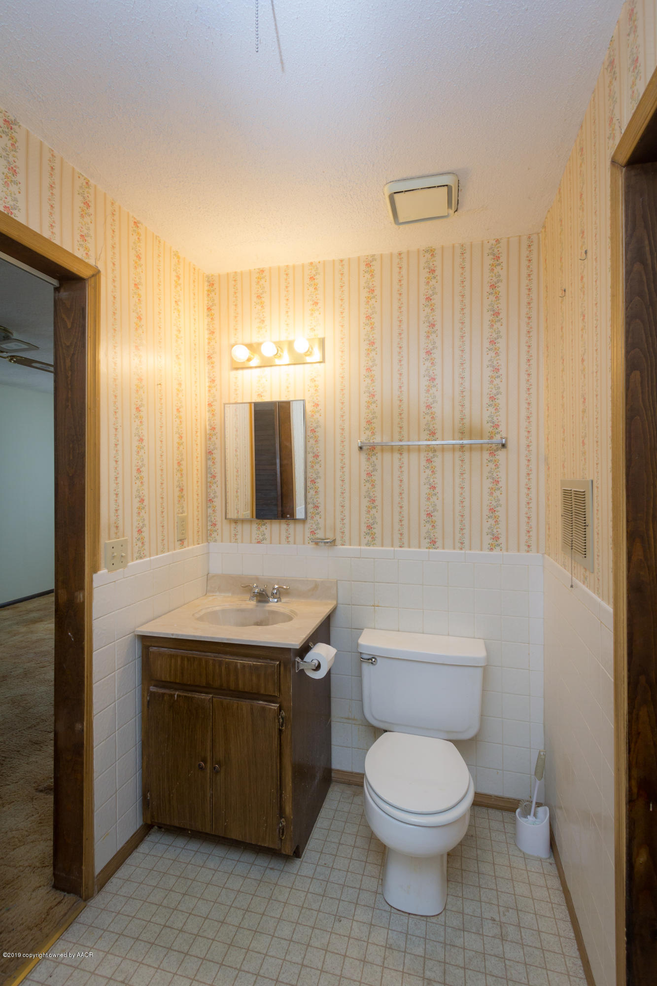 4606 Bowie Street Amarillo, TX 79110 - Photo 18 of 42 a bathroom with a toilet a sink and mirror
