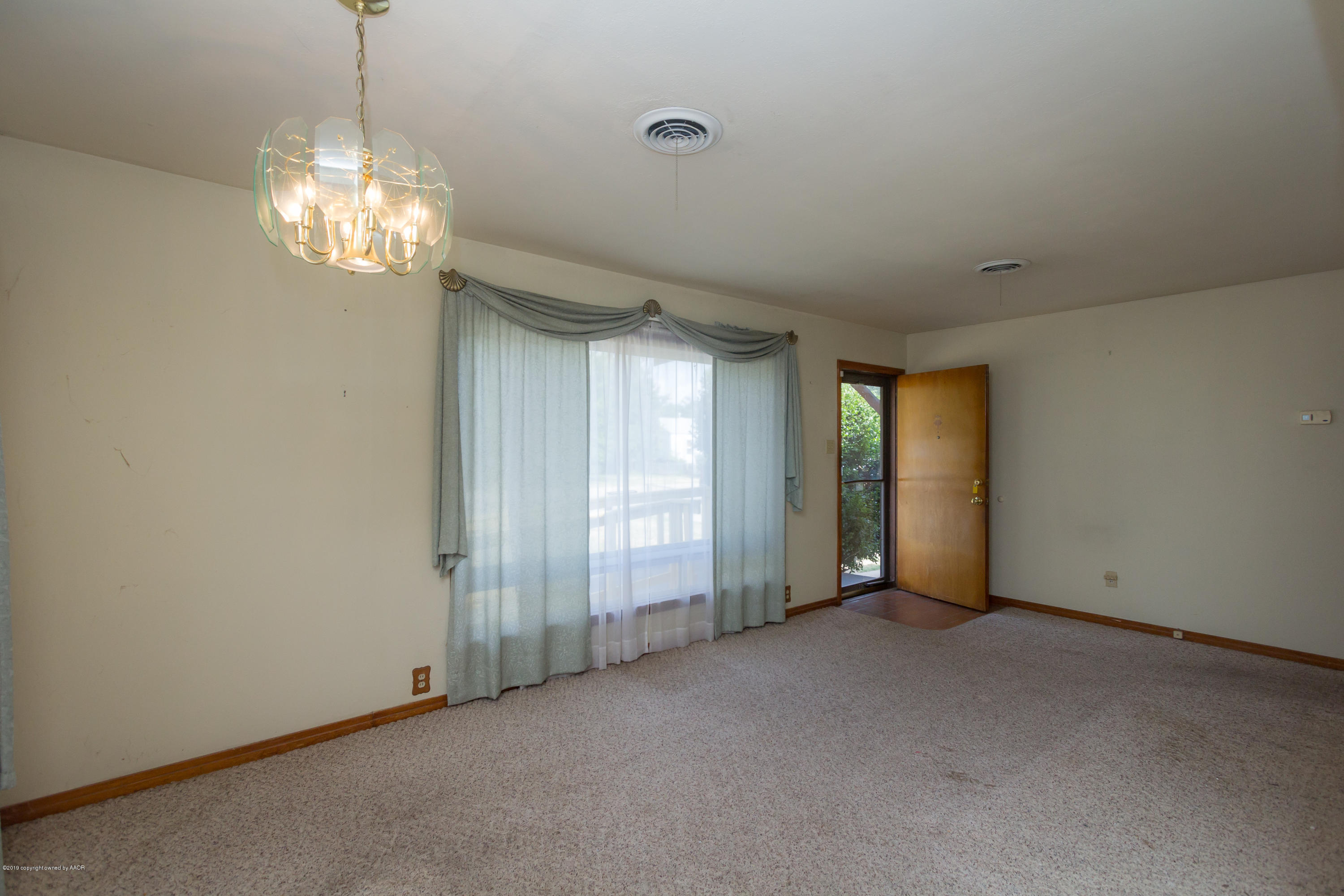 4606 Bowie Street Amarillo, TX 79110 - Photo 29 of 42 an empty room with chandelier fan and windows