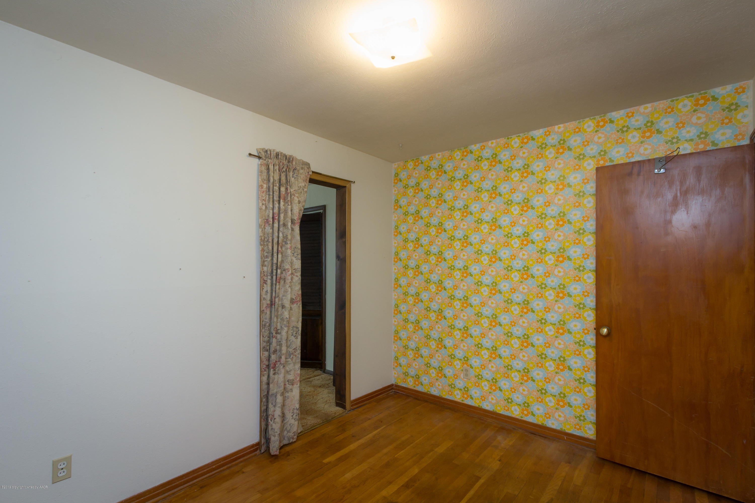 4606 Bowie Street Amarillo, TX 79110 - Photo 9 of 42 an empty room with wooden floor and closet