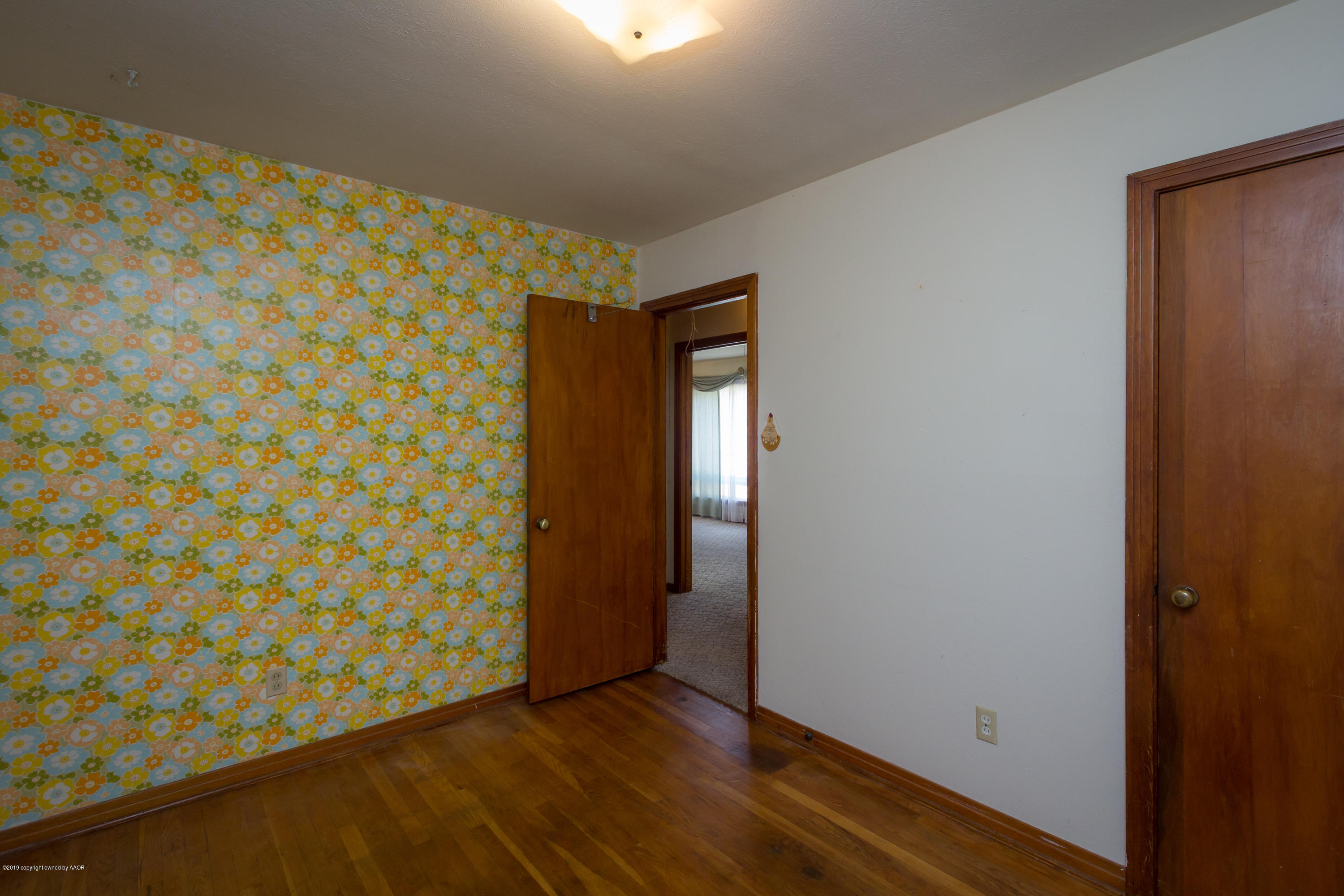 4606 Bowie Street Amarillo, TX 79110 - Photo 10 of 42 a view of an empty room with wooden floor and a window