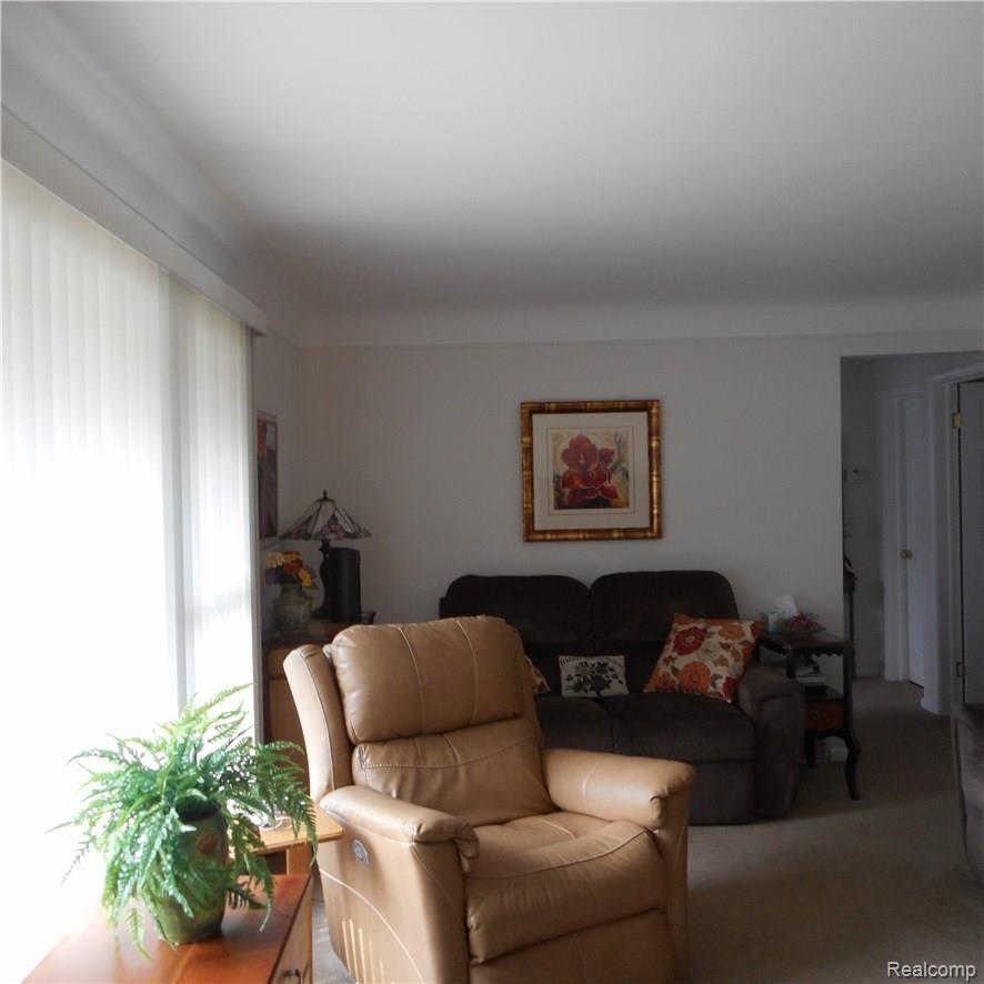 Large living room has hardwood floors under new plush carpet. 
