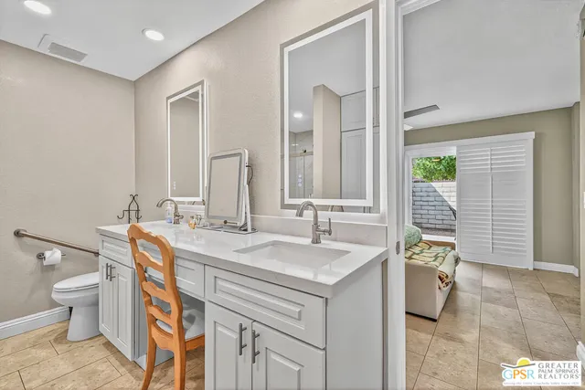 a spacious bathroom with a double vanity sink toilet and a mirror