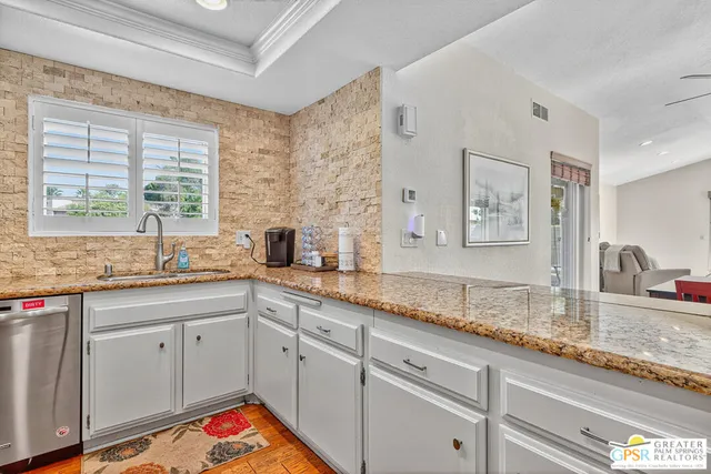 a white kitchen with sink and window