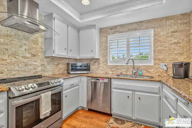a kitchen with granite countertop cabinets stainless steel appliances and a sink