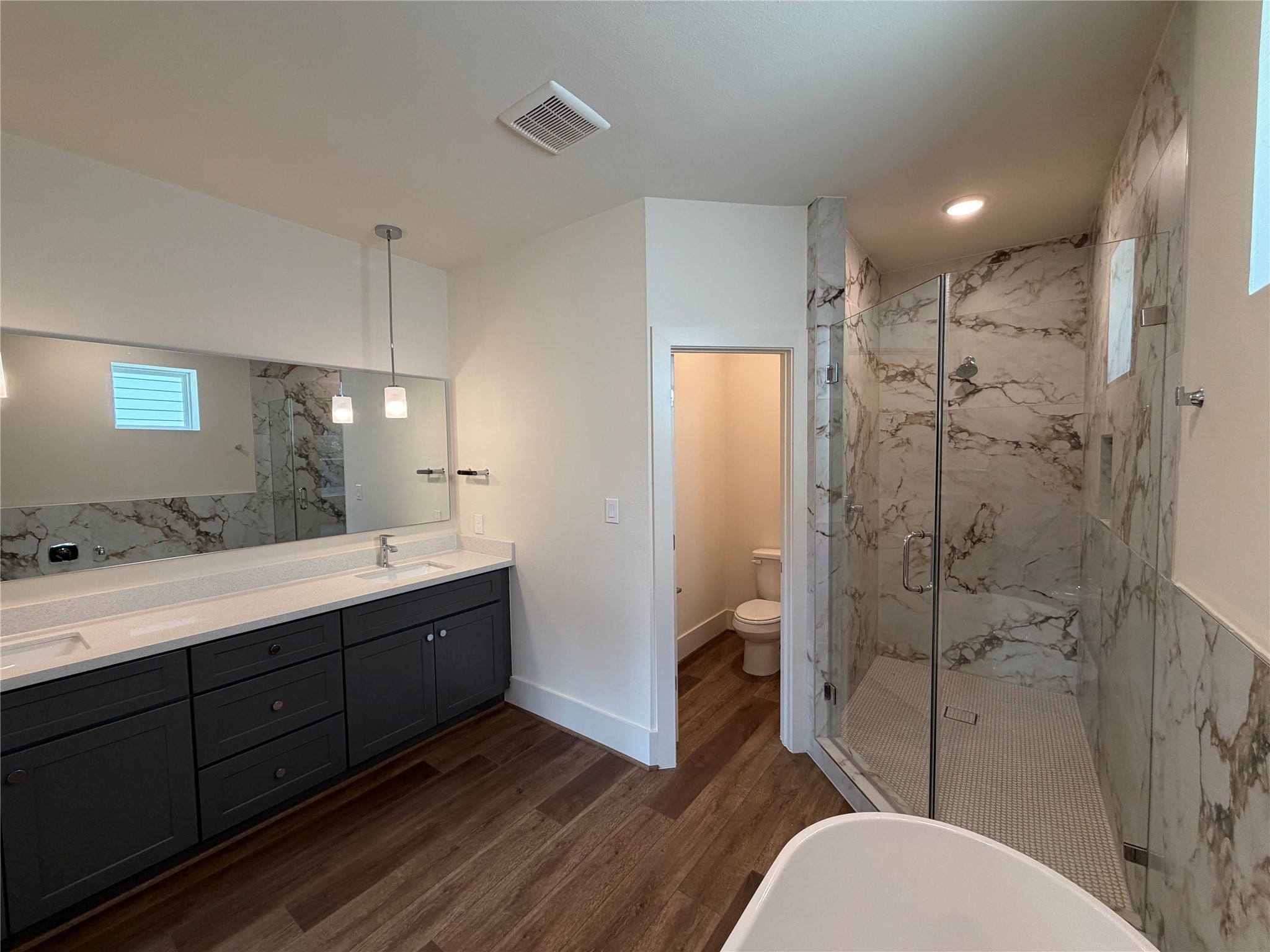 879 Rachel Street, Unit E Houston, TX 77091 - Photo 26 of 34 a bathroom with a double vanity sink toilet mirror and shower