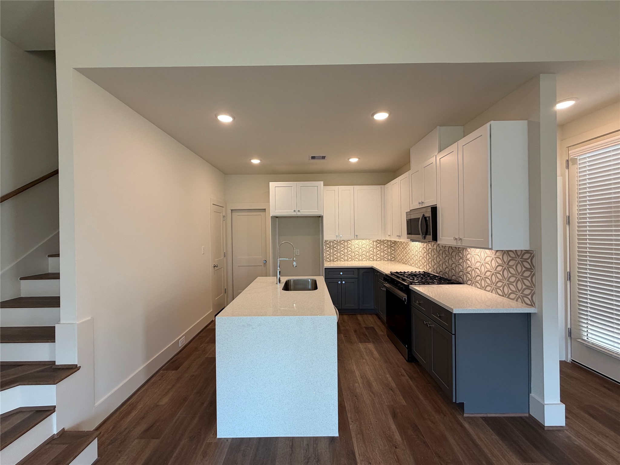879 Rachel Street, Unit E Houston, TX 77091 - Photo 10 of 34 a large kitchen with stainless steel appliances kitchen island a large counter top and a wooden floors