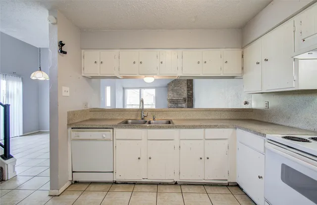 a kitchen with white cabinets stainless steel appliances and sink