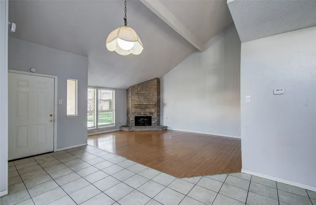 an empty room with fireplace and windows