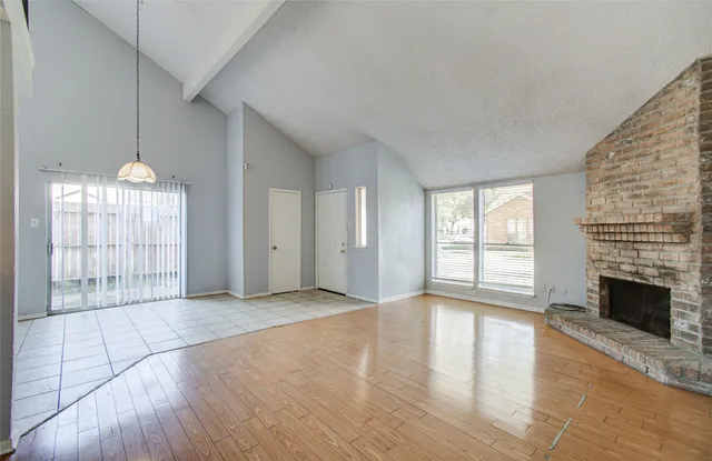 a view of an empty room with a fireplace and a window
