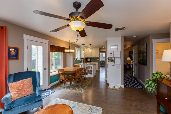 a living room with furniture kitchen view and a large window