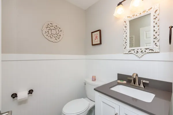 a bathroom with a granite countertop sink mirror vanity and toilet