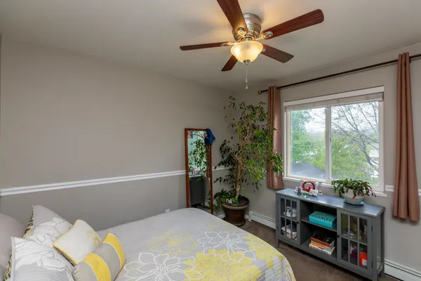 a bedroom with a bed a large window with table and chairs