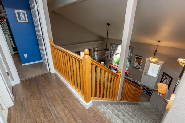a view of a hallway with wooden floor and stairs