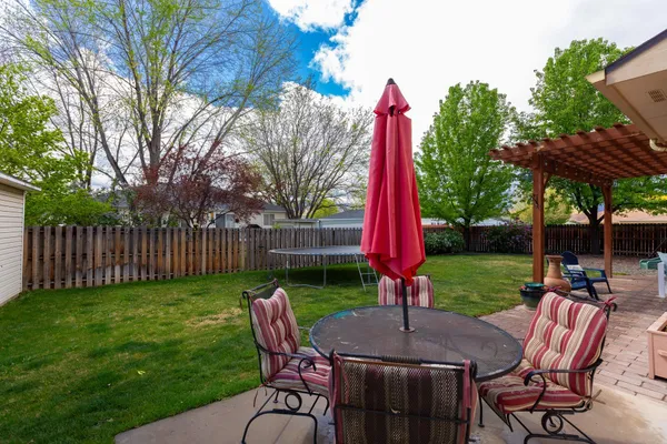 a view of a table and chairs in backyard of the house