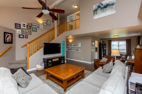 a living room with furniture a ceiling fan and a flat screen tv