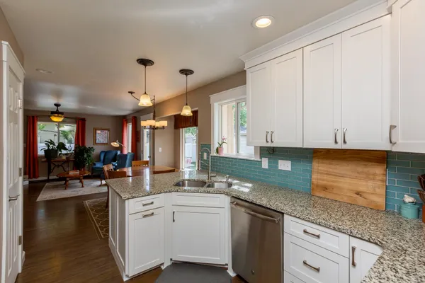 a kitchen with white cabinets and sink